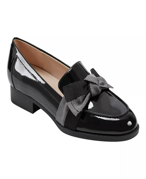 Black patent leather loafer with a bow on a white background