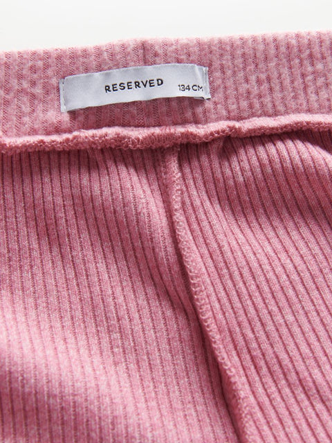 Close-up of pink ribbed fabric with a 'Reserved' tag.