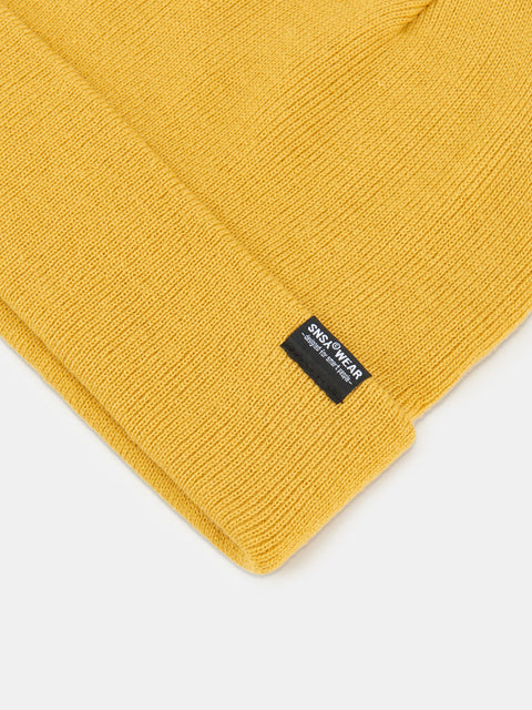 Yellow knit beanie with a brand label on a white background
