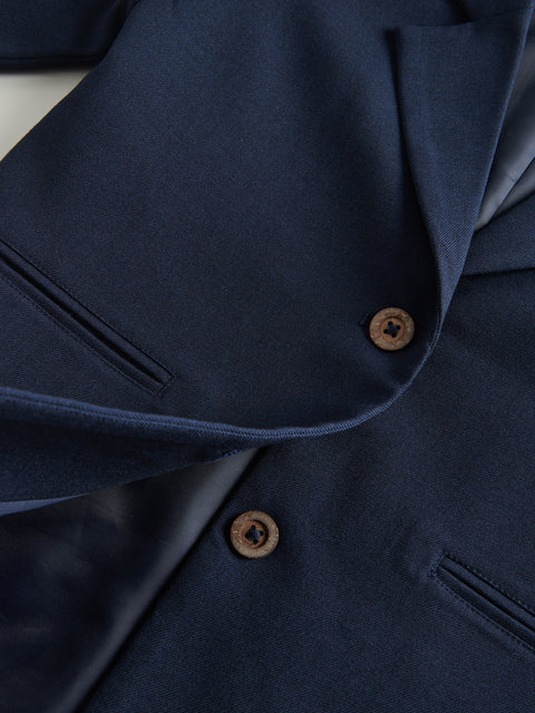 Close-up of a navy blue jacket with buttons on a white background
