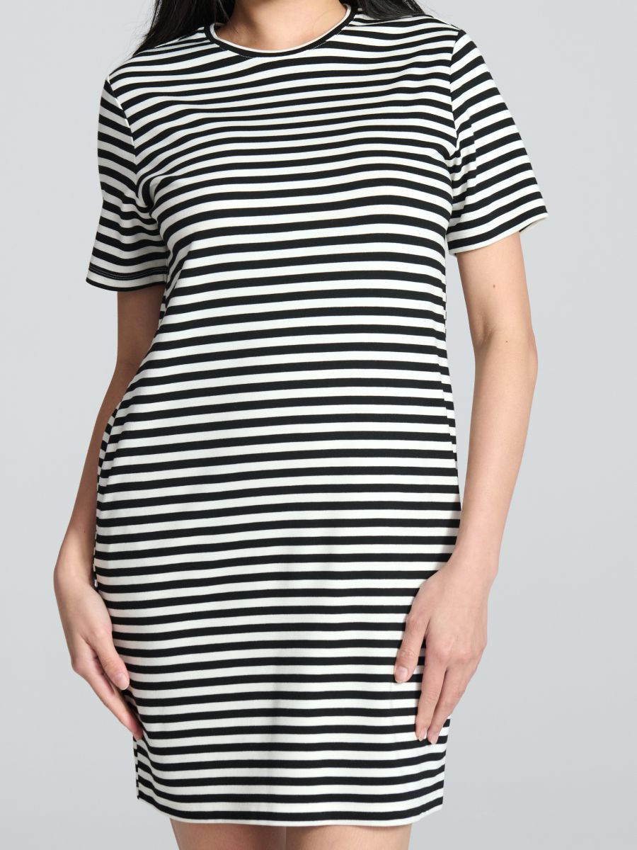Black and white striped dress worn by a person on a gray background