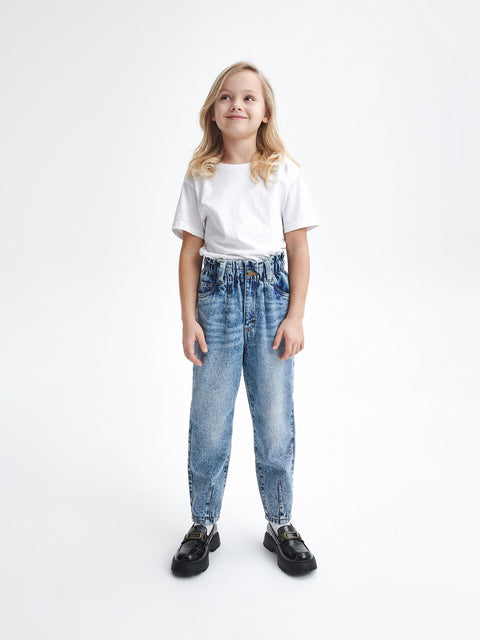 Young girl wearing a white t-shirt and blue jeans on a white background