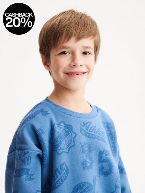 Child wearing a blue sweatshirt with logos on a white background
