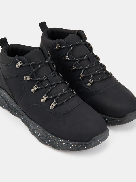 Black high-top sneakers with speckled sole on a light gray background