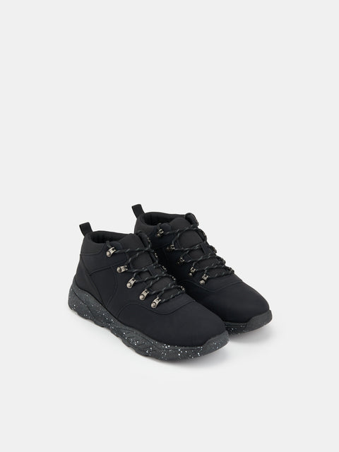 Black high-top sneakers on a light gray background