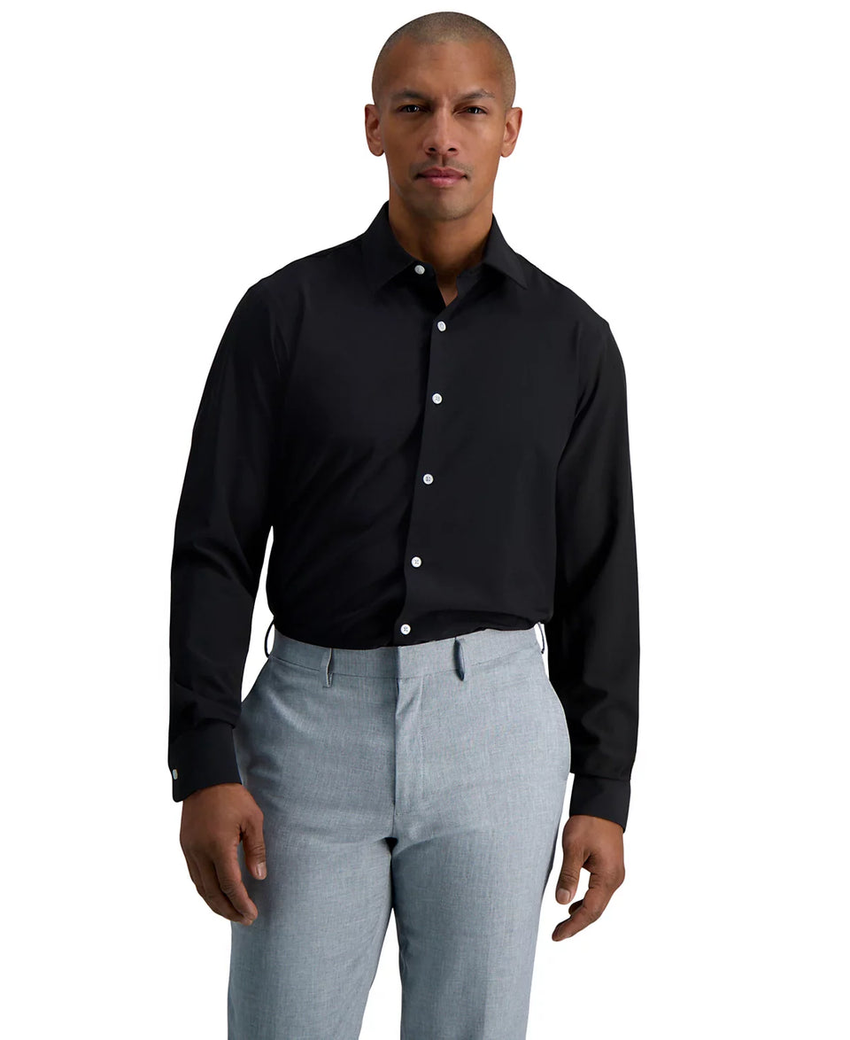 Man wearing a black dress shirt and light gray pants on a white background