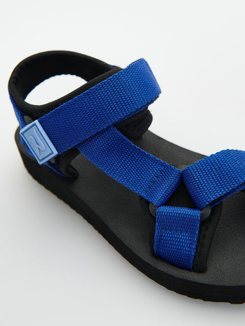 Black sandal with blue straps on a white background