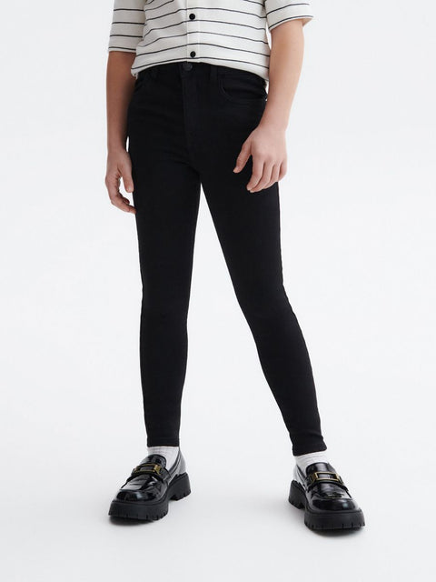 Person wearing black leggings and a striped shirt on a white background