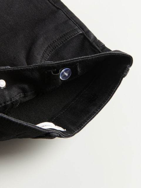 Close-up of a black denim jacket with metal buttons on a white background