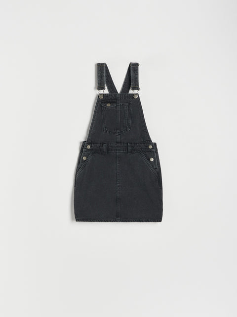 Black denim pinafore dress on a light gray background