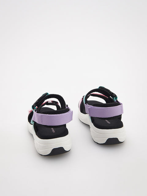 Black and white sandals with purple straps on a white background