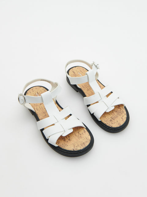 Pair of white sandals with cork soles on a light gray background
