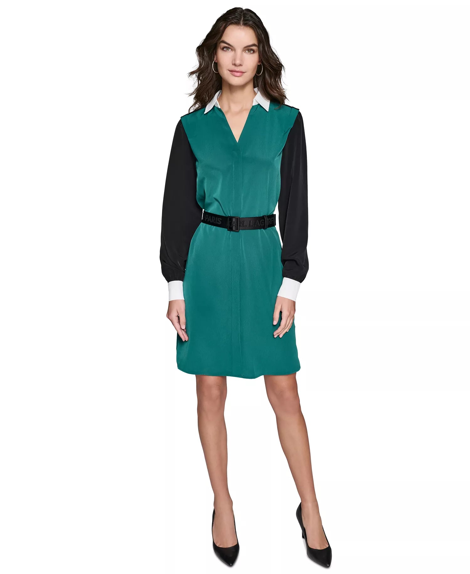 Woman wearing a teal dress with black sleeves and belt on a white background