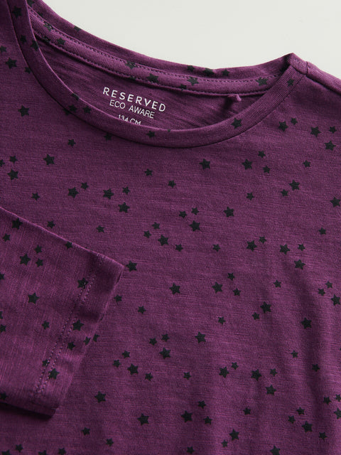 Purple t-shirt with black star patterns and 'Reserved' label on collar