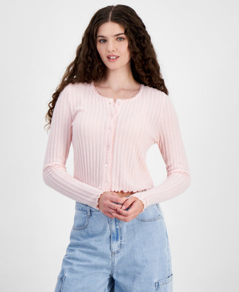 Woman wearing a light pink ribbed sweater and blue jeans on a white background