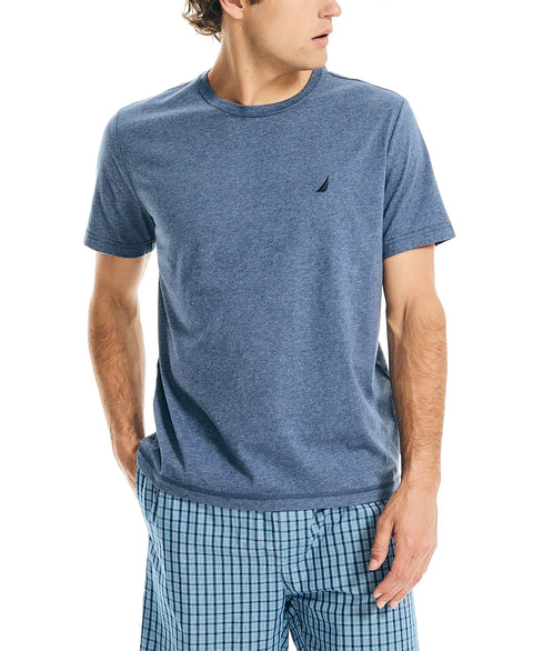 Man wearing a blue t-shirt and checkered shorts on a white background