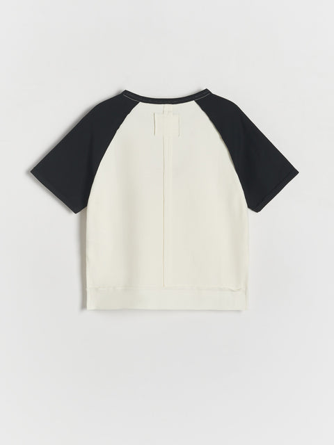 White t-shirt with black sleeves on a light gray background