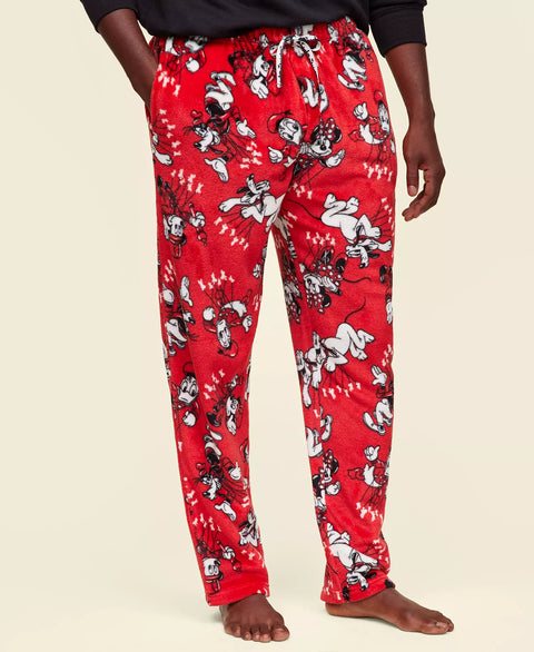Red pajama pants with cartoon character print worn by a person on a beige background