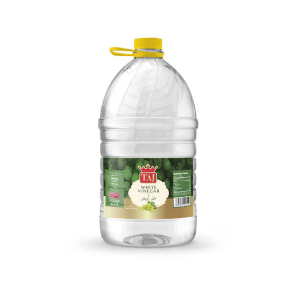 Clear bottle of white vinegar with a yellow cap on a white background