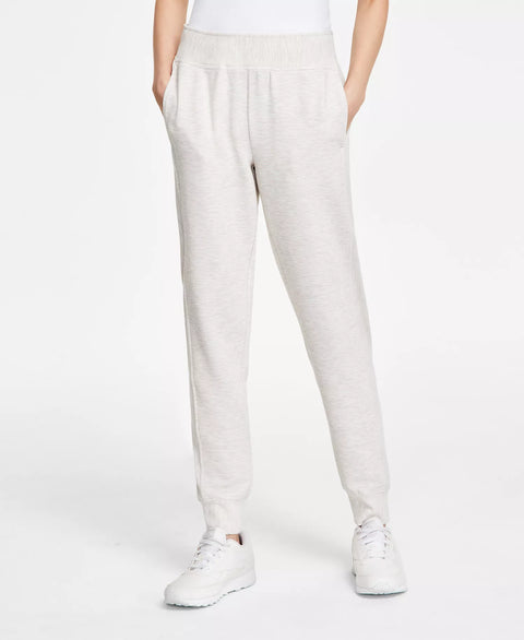 Person wearing light-colored pants and white sneakers on a plain background