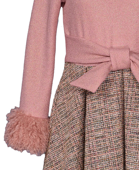 Pink sweater with fluffy cuffs and a patterned skirt on a white background