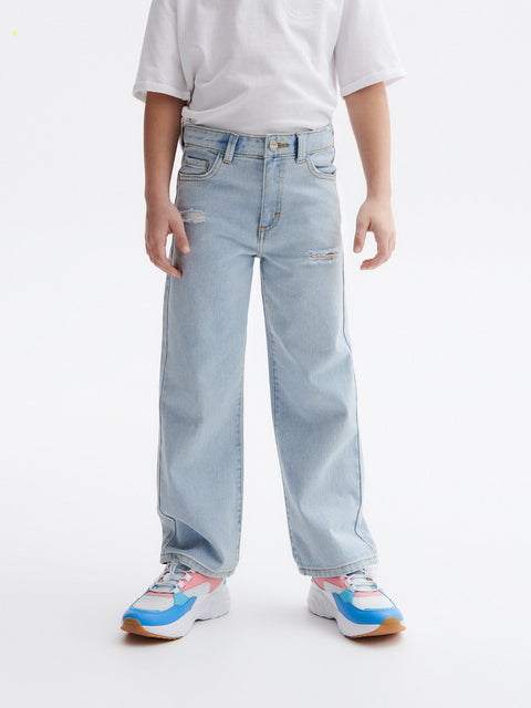 Person wearing light blue jeans and colorful sneakers on a white background