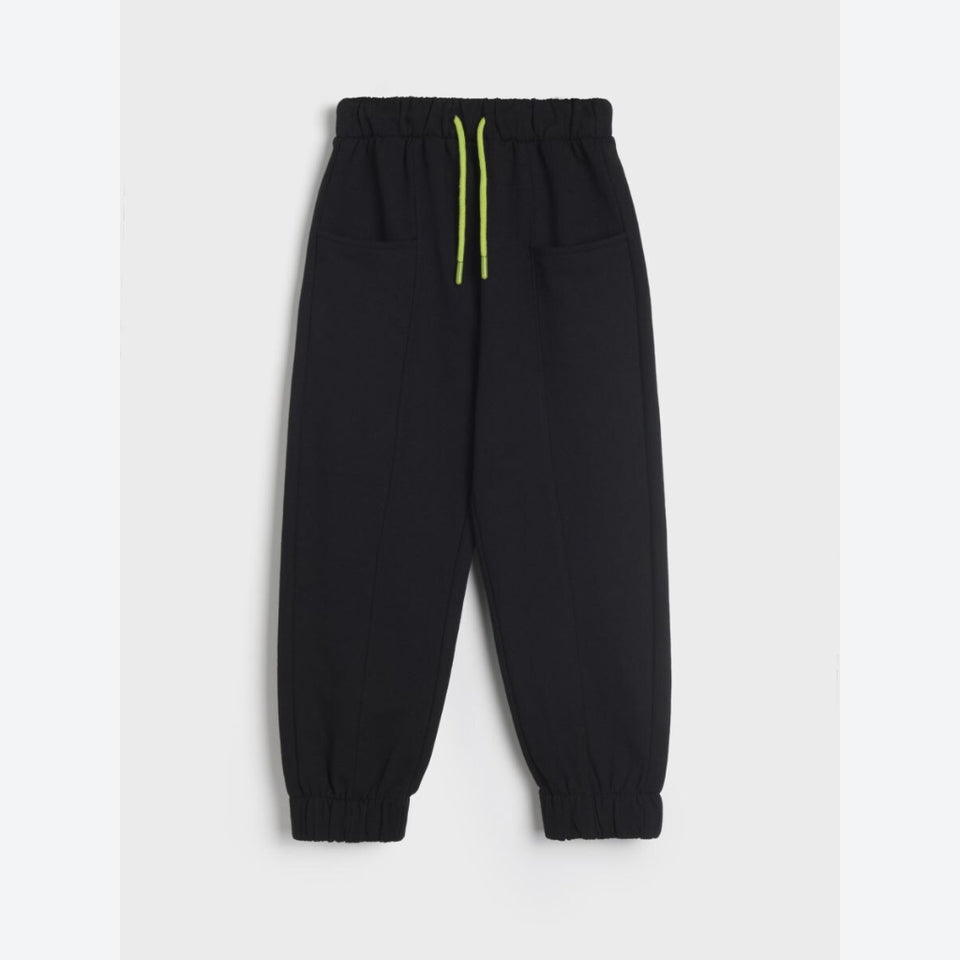 Black jogger pants with an elastic waistband, side pockets, and bright neon yellow-green drawstrings, shown flat on a light gray background.