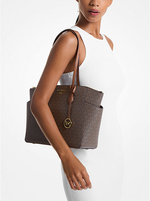 Woman holding a brown tote bag with a visible brand logo on a white background