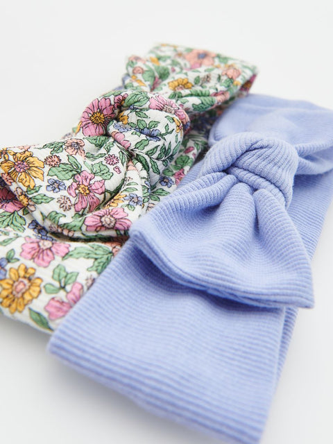 Floral-patterned fabric and a light blue knitted item on a white background