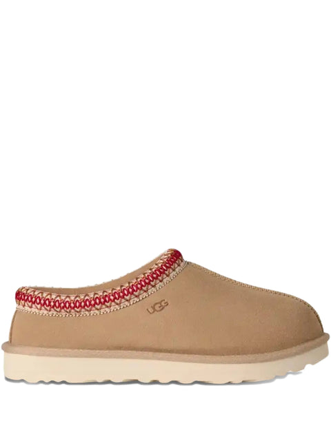 Tan UGG slipper with red and white pattern on a white background