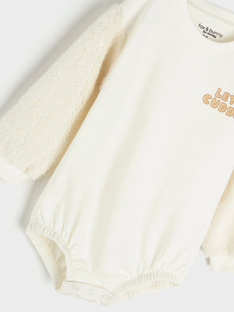 Close-up of a baby outfit with text on a white background