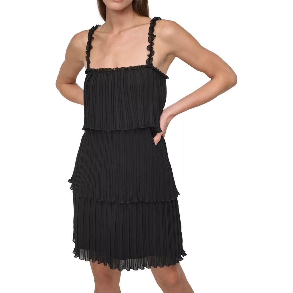 A woman modeling a black pleated tiered mini dress with ruffled shoulder straps against a plain white background.