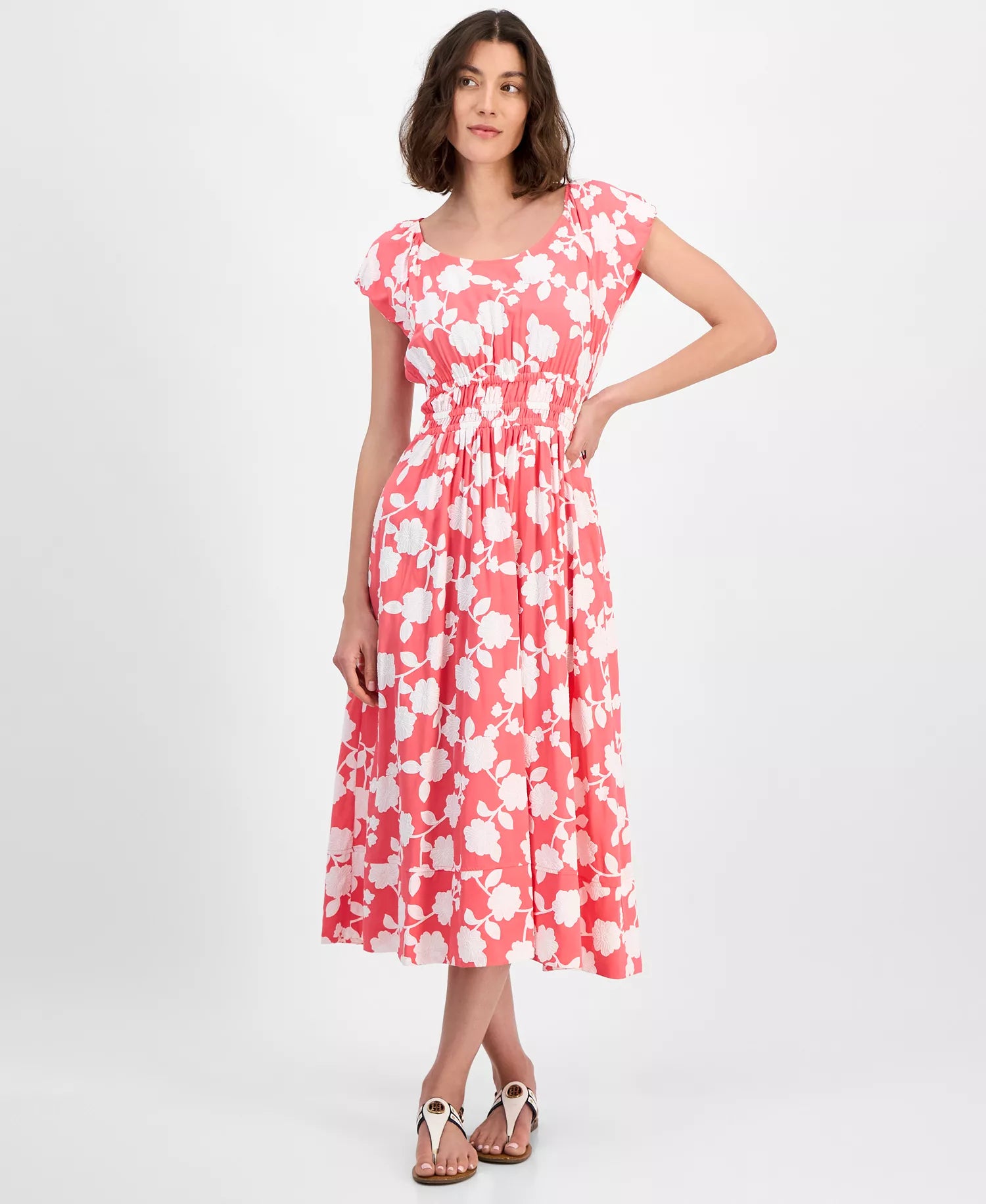 Woman wearing a pink floral dress on a white background