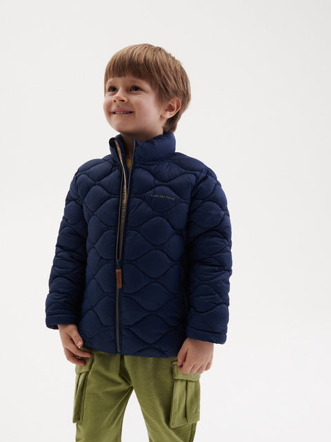 Child wearing a blue quilted jacket on a white background