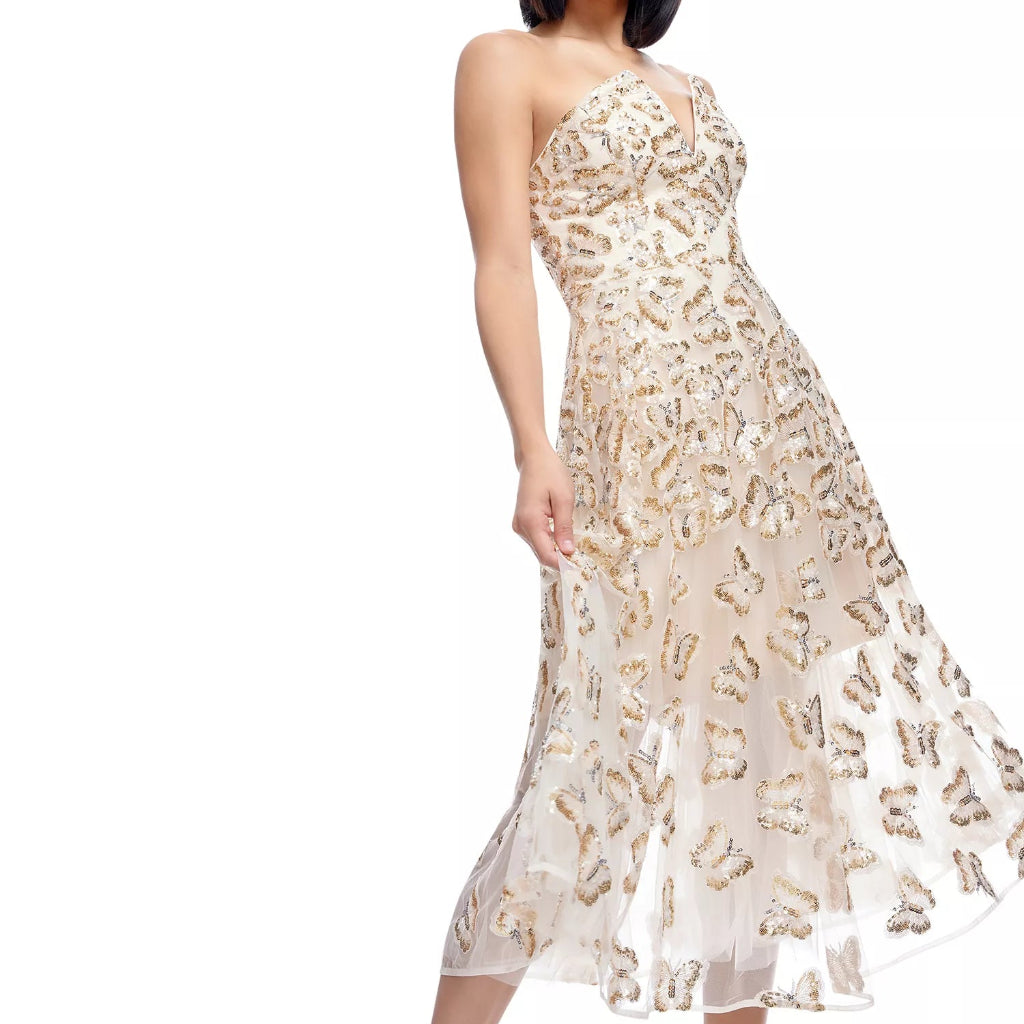 A woman modeling a strapless midi dress with a fitted bodice and flowing skirt, covered in shimmering gold and champagne butterfly motifs over a sheer nude base, set against a plain white background.