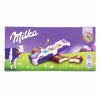 Milka chocolate bar packaging with a cow and nature background