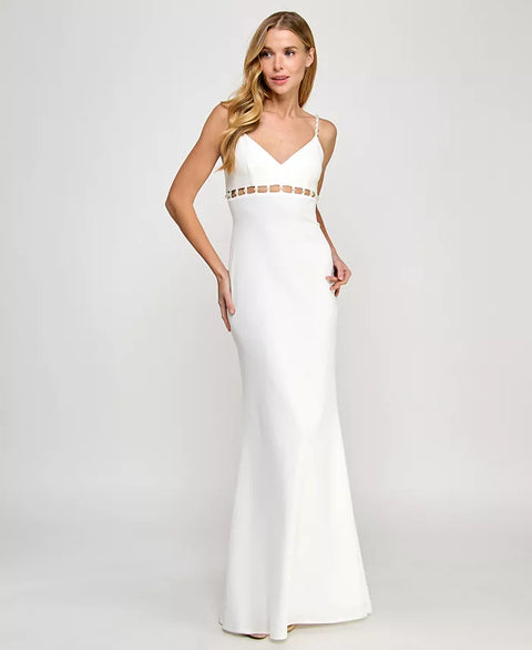 Woman wearing a white evening gown with gold accents on a plain background