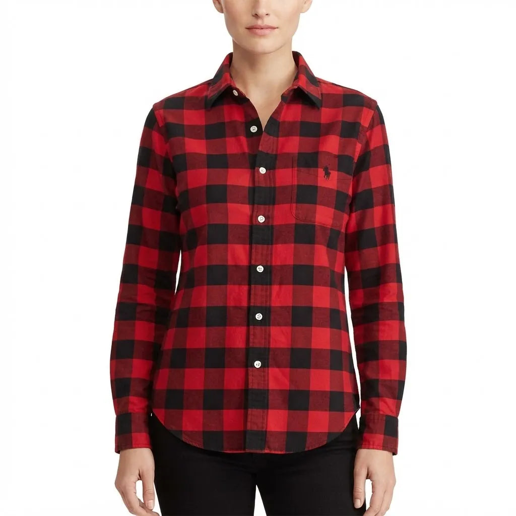 A woman wearing a red and black buffalo plaid button-down shirt with a small embroidered polo pony logo on the left chest, paired with black pants, against a plain white background.