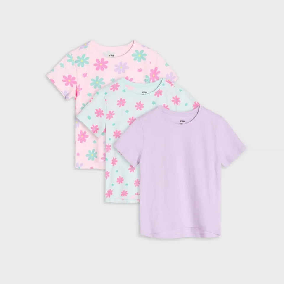 Three short-sleeve kids' t-shirts in a stacked arrangement on a light gray background. The top shirt is light pink with a pink and mint green flower pattern.