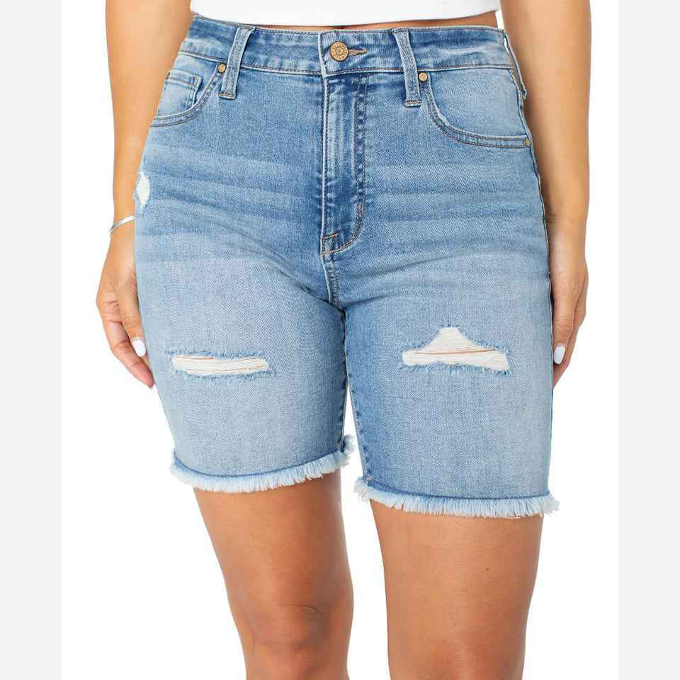 Light wash blue denim shorts with distressed rips and frayed hems, shown on a model against a white background.