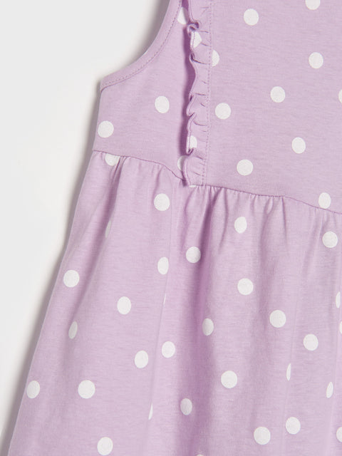 Purple dress with white polka dots on a light gray background