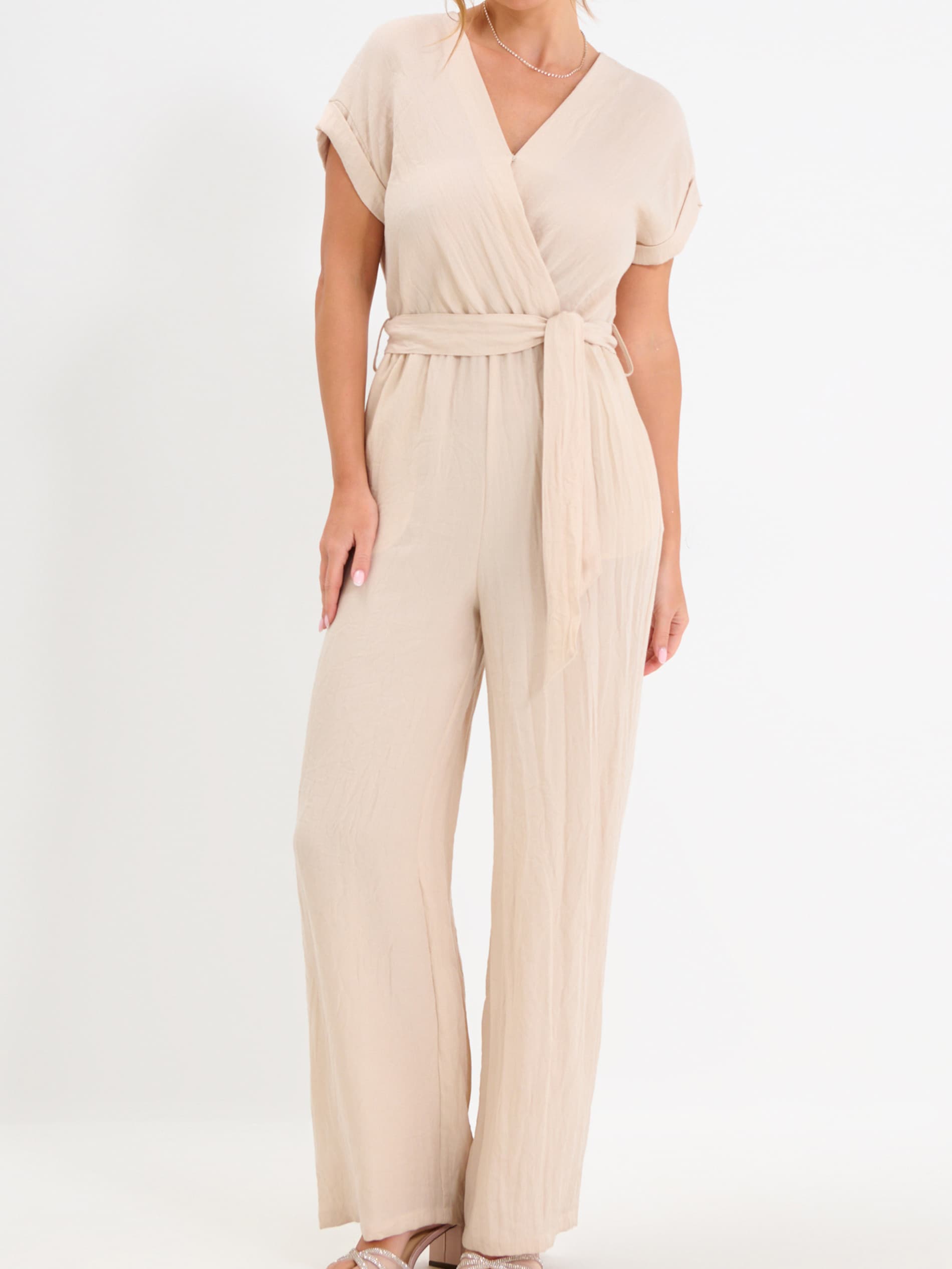 Beige jumpsuit worn by a person on a white background