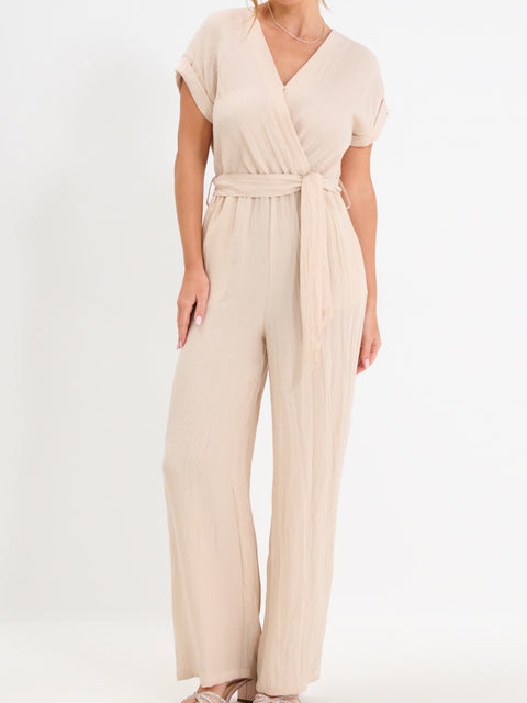 Beige jumpsuit worn by a person on a white background