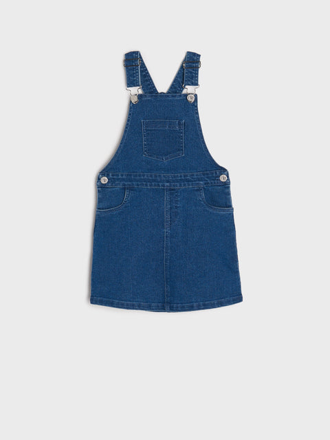 Blue denim pinafore dress on a white background