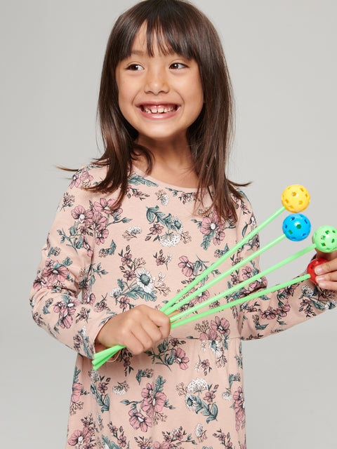Child holding colorful sticks with a gray background