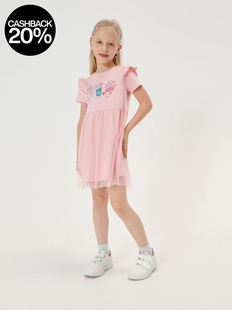 Young girl wearing a pink dress with ruffled sleeves on a white background