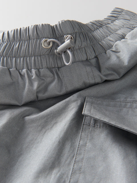 Close-up of gray pants with a drawstring waistband on a light gray background