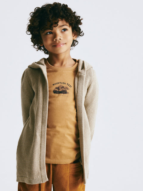 Child wearing a beige cardigan over a brown t-shirt with 'Mountain View' graphic on a white background