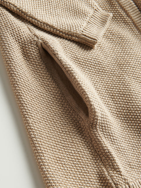Close-up of a beige knitted sweater on a light background