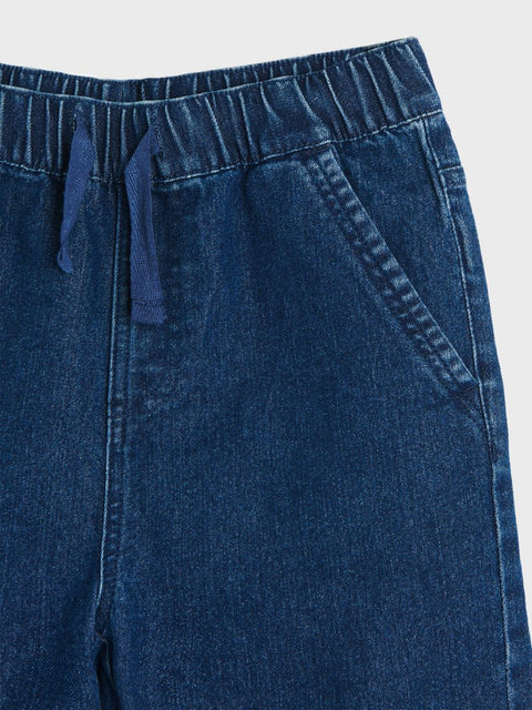 Close-up of blue denim pants on a light gray background